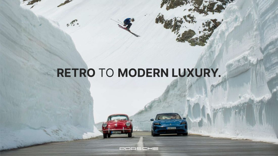 Slide: Retro to modern luxury, a classic and a modern car on a road cut through tall snow walls