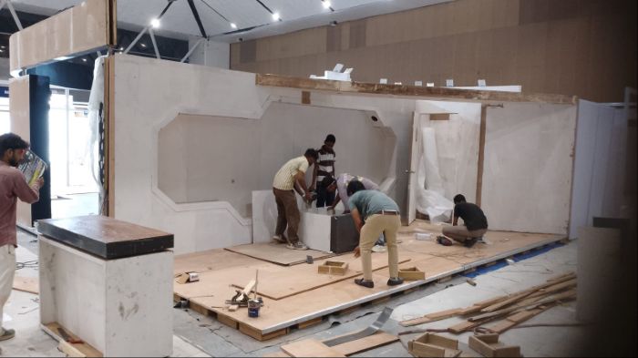 Carpenters assembling the same stall on site, with the bevelled frame cut but not yet finished