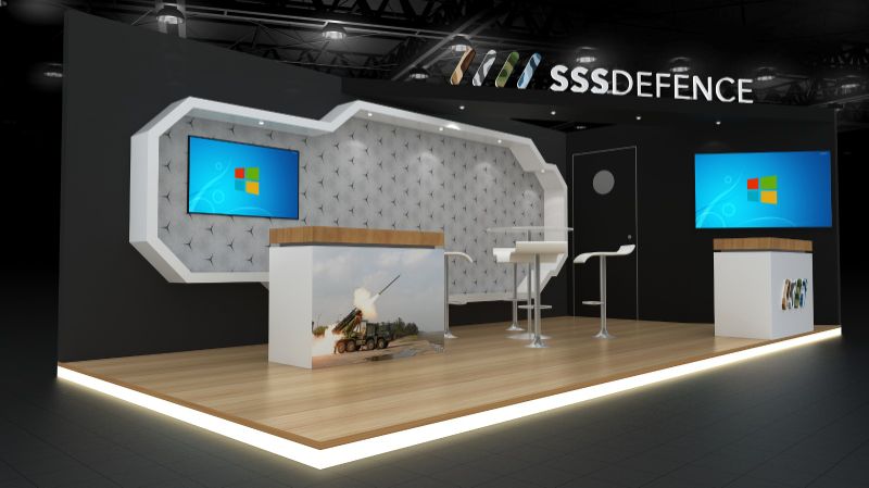 Aedex 2026 stall render: black booth with a white bevelled frame around a patterned wall, and a counter wrapped in a rocket-launcher photograph