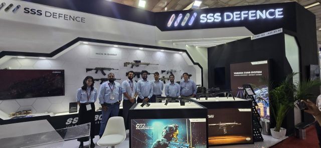 The SSS Defence team standing in front of the finished Police Expo stall, with a lit fascia, a rifle wall marked Made in Bharat and a Varaha CUAS system panel